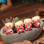 Set of four cute pink resin pigs holding red LOVE letters in a succulent planter pot