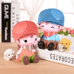 Cute resin cartoon couple dolls with small dogs sitting on decorative white books