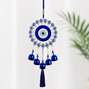 Close-up of royal blue Evil Eye wind chime with five metallic bells and silk tassel
