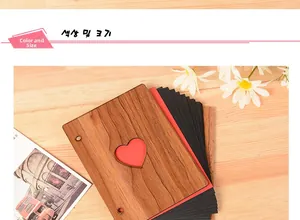 Detail of walnut wood photo album with heart cutout and black cardstock pages