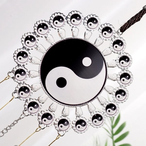 Detail of Yin Yang metal hanging decor featuring polished silver rings and woven lanyard