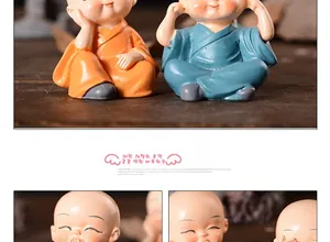 Detailed view of four resin monk figurines in orange and blue robes for car dashboard
