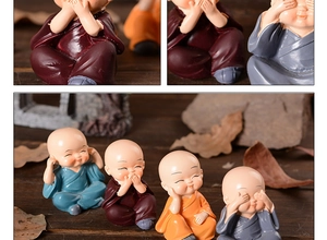 Detailed view of four small monk resin figurines in blue, red, orange and grey colors