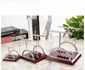 Three sizes of Newton's Cradle balance balls on a red base with metal support