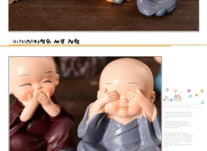Detail view of two cute resin Shaolin monks in red and blue robes with vivid expressions