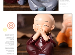 Close-up of a cute resin little monk figurine in red robe with a shy smiling face