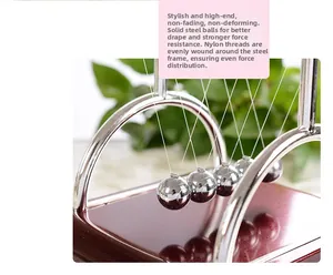 Close-up of solid steel balls and nylon strings on a classic T-shaped Newton's cradle