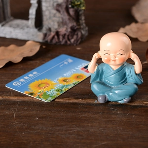 Cute Shaolin monk resin ornament in blue robe showing the see-no-evil zen gesture