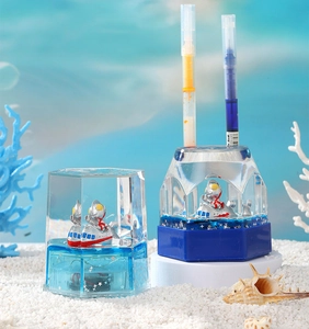 Detail of ocean-themed liquid sand timer and pen holder with blue sparkles and characters