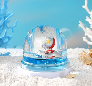Macro detail of Ultraman figure in liquid hourglass on sand with seashells and coral