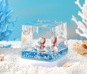 Detail of blue liquid sand bottle with cartoon hero figure and star glitters