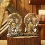 Detail of Totoro crystal balls with LED lights on silver and bronze heart bases