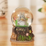Close-up of Totoro crystal ball featuring a detailed tree stump base and interior landscape