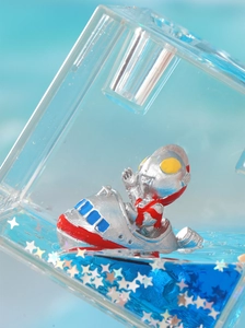 Macro shot of liquid motion timer featuring mini superhero figure in blue fluid with glitters