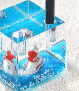 Detail of blue liquid pen holder with Ultraman figure and silver star sequins