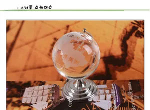 Detailed view of clear crystal globe with frosted map engraving on a silver metal stand