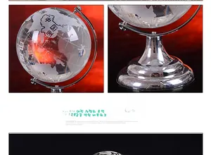 Detail of crystal world globe on silver metal stand with etched world map and base