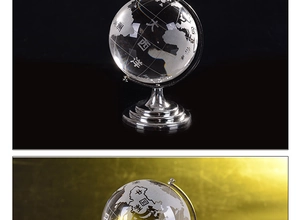 Macro shot of a crystal globe with engraved continents and polished silver metal stand