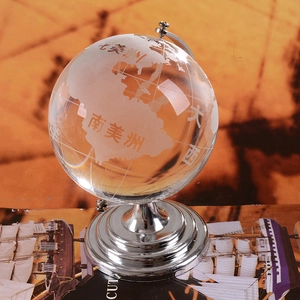 Clear crystal globe orb with silver metal base on a vintage map background