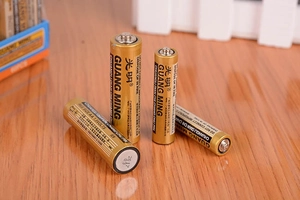 Vier AA 1,5V Batterien auf Holzoberfläche für Haushaltsspielzeug und Uhren