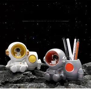 Close-up of astronaut pen holder night light on moon rock with cosmic starry background
