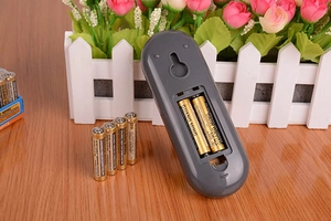 Detail des Batteriefachs mit zwei AA-Kohlebatterien auf einer Holzoberfläche