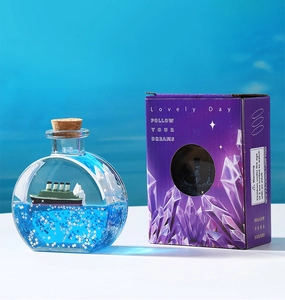 Vue détaillée d'une bouteille de fluide avec navire et son coffret cadeau violet élégant