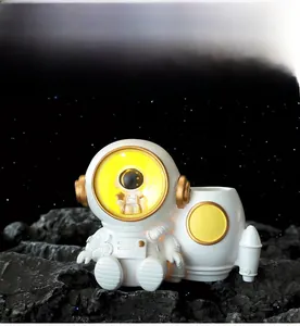 Detail of astronaut LED night light pen holder on lunar surface with starry background