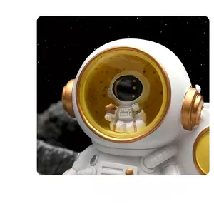 Close-up of 3D astronaut figurine featuring a miniature model inside the yellow helmet visor