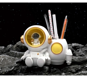 Close-up of white resin astronaut desk organizer with gold accents on lunar surface base