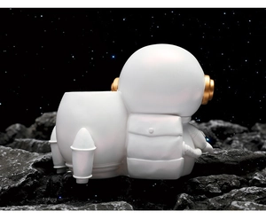 Detail of astronaut rocket desktop organizer with white matte finish and golden accents