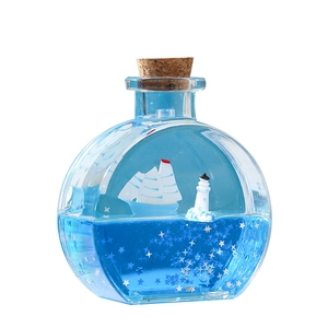 Sablier liquide nautique avec voilier flottant et paillettes étoiles en mer bleue