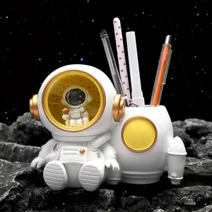 Astronaut pen holder desk ornament with white and gold accents and starlight lamp feature