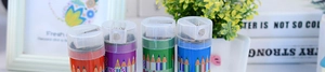 Close-up of colorful cylindrical pencil cases with sharpeners for students