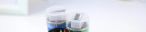 Macro detail of pencil sharpener lid on storage tube with colorful drawing pencils inside