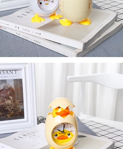 Detail of creative yellow chick alarm clock with shell design and analog display