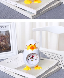 Detail view of the yellow cartoon chicken alarm clock on a minimalist home decor setup