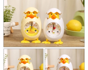 Close-up of creative chicken eggshell alarm clocks in cream and white for student bedside