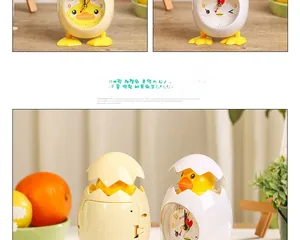 Macro detail of cute chick-shaped eggshell alarm clocks on a wooden bedside table