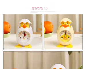 Close-up of cute chick alarm clocks with clear Arabic numerals on a modern desk