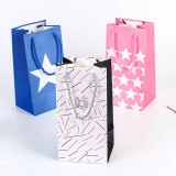 Nahaufnahme von Geschenktüten aus Papier mit blauen Sternen, Rosa und Streifenmuster