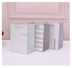 Blue and white striped paper gift bags with reinforced woven handles and matte finish