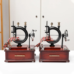 Vintage sewing machine music box with mahogany base and miniature sewing accessories