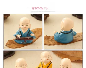 Detail view of small monk resin figurines playing musical instruments for home decor