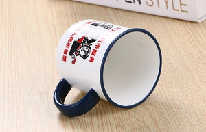 Close-up of retro ceramic mug with vintage portrait and red slogan on wooden desk