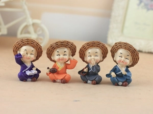 Detailed view of four resin monk figurines in colorful robes with straw hats home decor