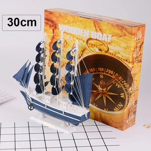 Close-up of a 30cm blue wooden sailing boat model with fabric sails and wooden base