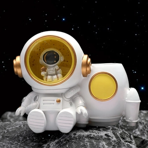 Astronaut night light and pen holder figurine on moon rock base for desk decor
