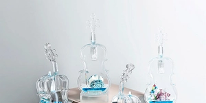 Detailed macro view of violin-shaped glass ornament with sea shells and blue liquid