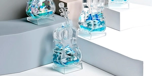 Blue liquid violin acrylic sculpture with dolphin models on geometric display blocks